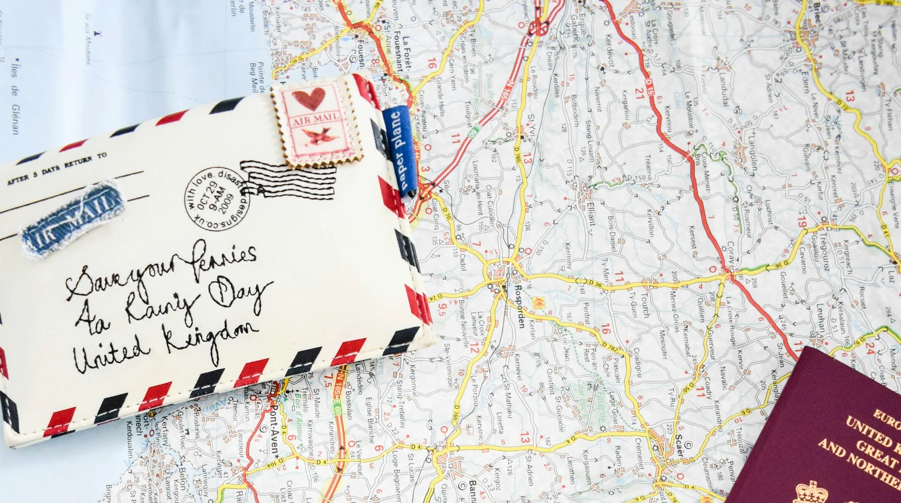 A real travel-planning flat lay with a paper map, camera, passport and route notes